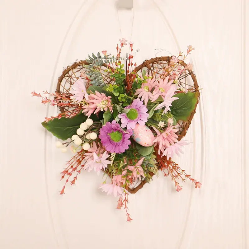 Artificial heart-shaped vine wreath with wild daisies, festive eggs, and green leaves.