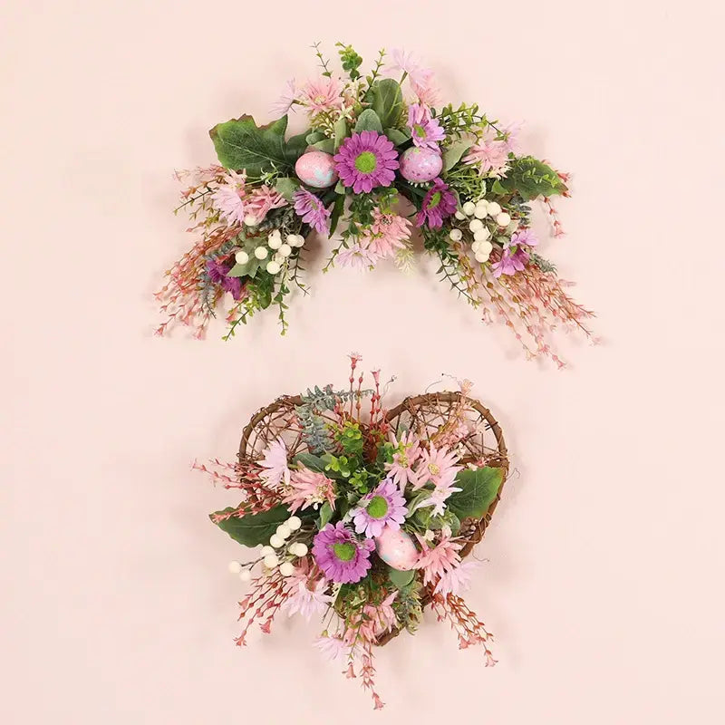 Artificial heart-shaped vine wreath with wild daisies, festive eggs, and green leaves.